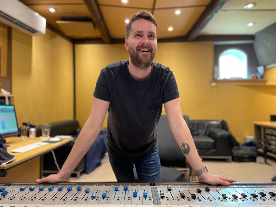 Elliot Vaughan leaning on a mixing desk in the studio